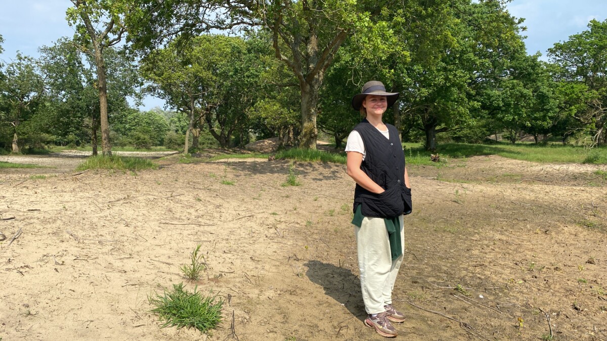 Jorinde Kuiper staat in een park met groene bomen op de achtergrond.