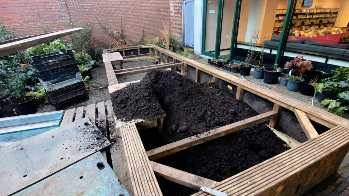 Tuinproject met houten plantenbakken en verse aarde voor tuinontwerp.